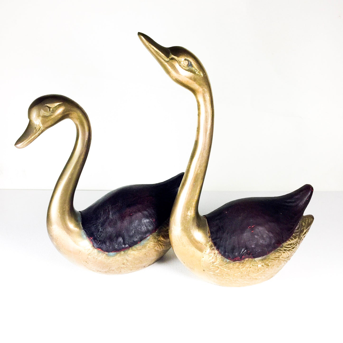 Pair of brass swans with leather accents